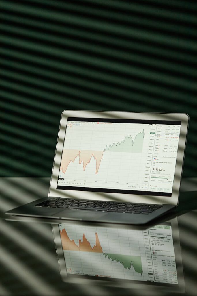 pexels-photo-7108043 A laptop shows a detailed financial graph with a clear reflection on a glossy surface.